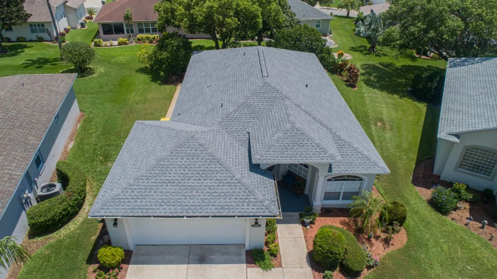 Aerial view of a completed Stronghold Roofing light-gray architectural shingle roof on a Florida single-story home