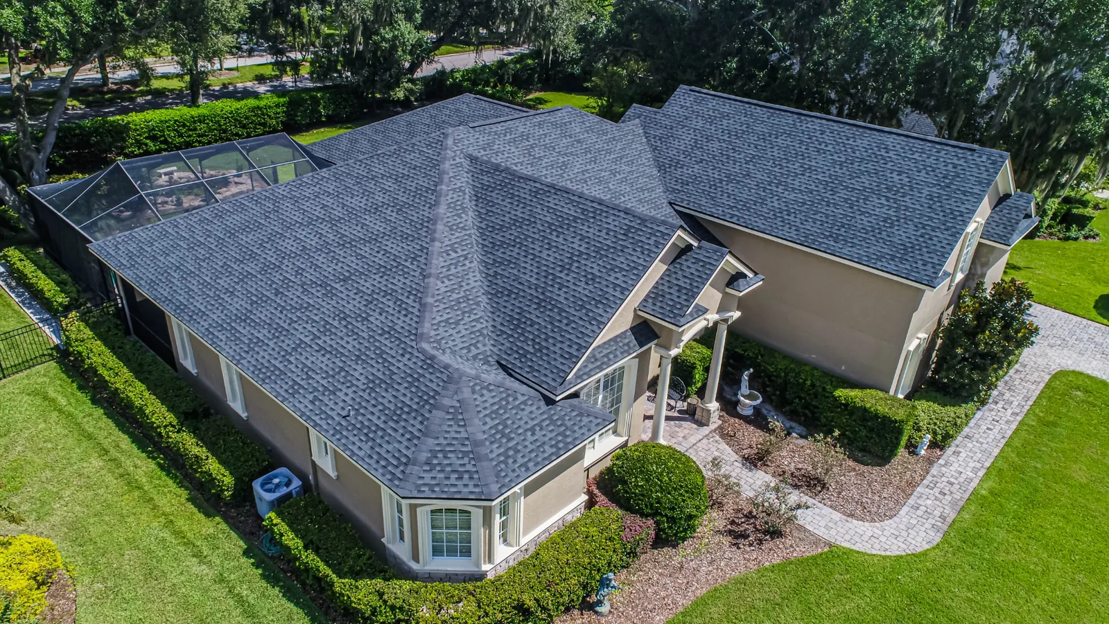 Aerial view of a Stronghold charcoal shingle re-roof with complex hip layout and lanai enclosure