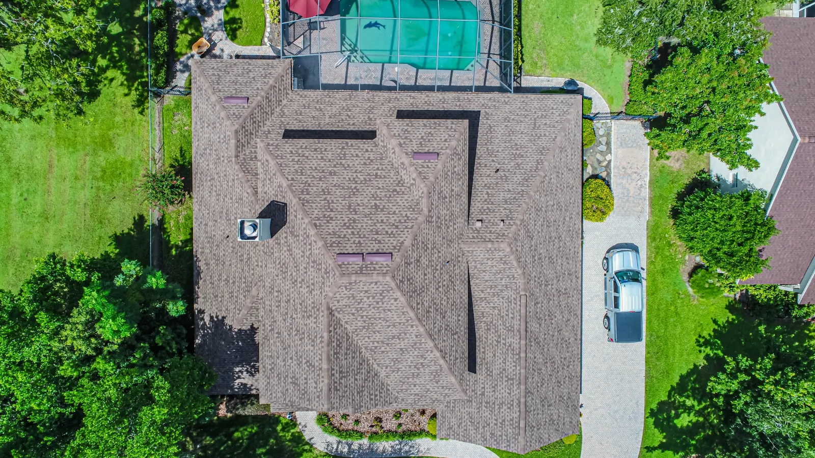 Aerial view of a Stronghold architectural shingle roof on a Florida home framed by oaks