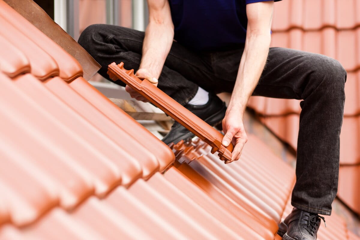 A roofer installing tiles over roof in Lakeland