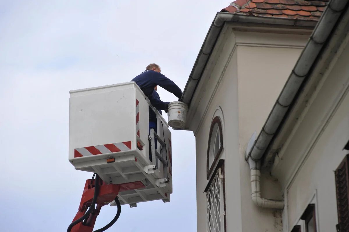 A man is cleaning gutter as part of roof repair in Lakeland