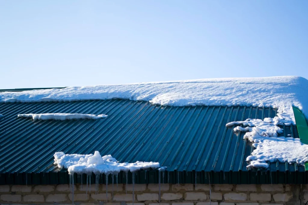 icicles hang from the iron green roof spring melting snow