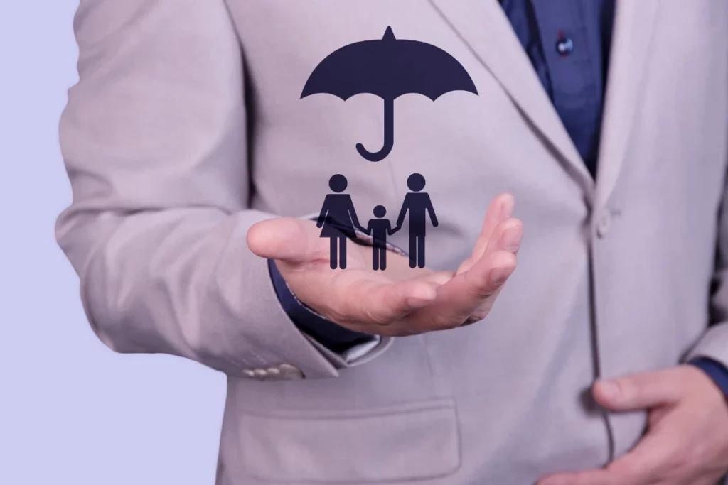 A businessman holds an umbrella on his hand, over a family concept, for protection, safety, finance and insurance. 