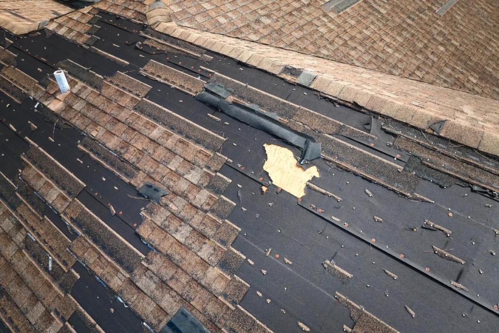 Wind damaged house roof with missing asphalt shingles after hurricane Ian in Lakeland, Florida Repair of home rooftop concept