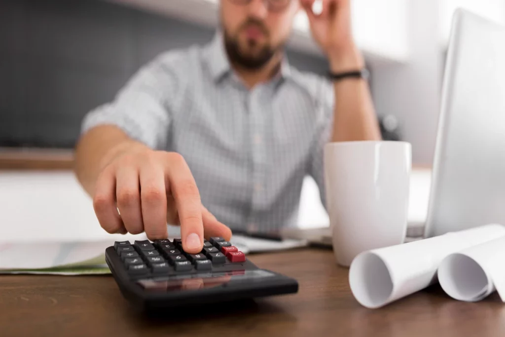 A man calculating roof price to avoid roofing scams