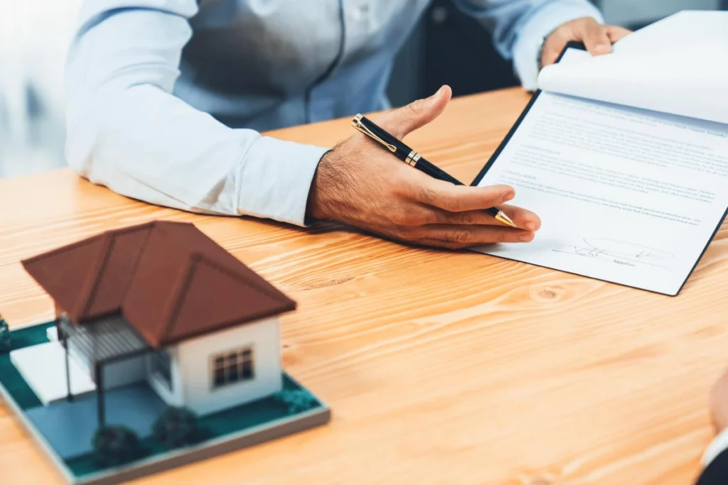 A real estate agent and a client signing a contract, ensuring a secure roofing agreement to avoid roofing scams.