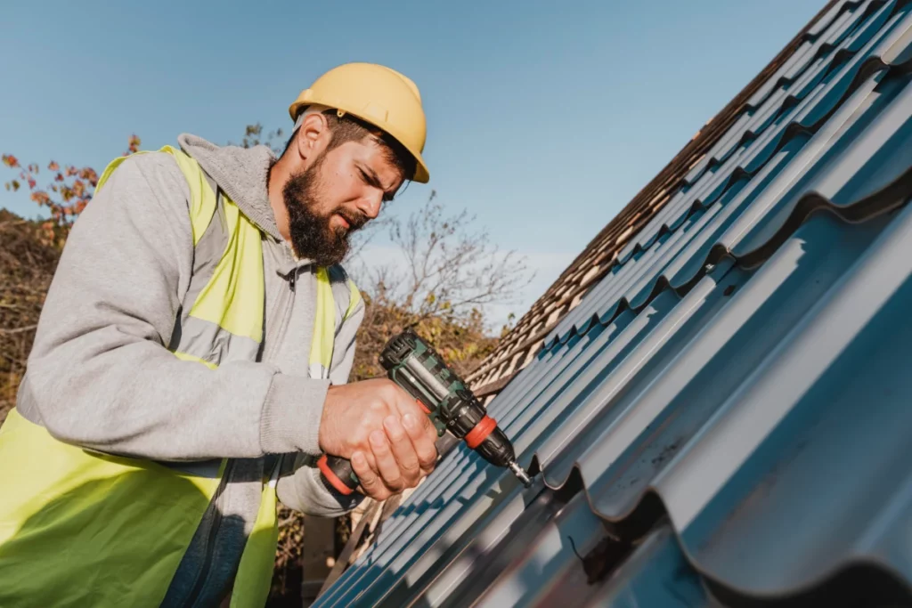 sideways man working roof with drill