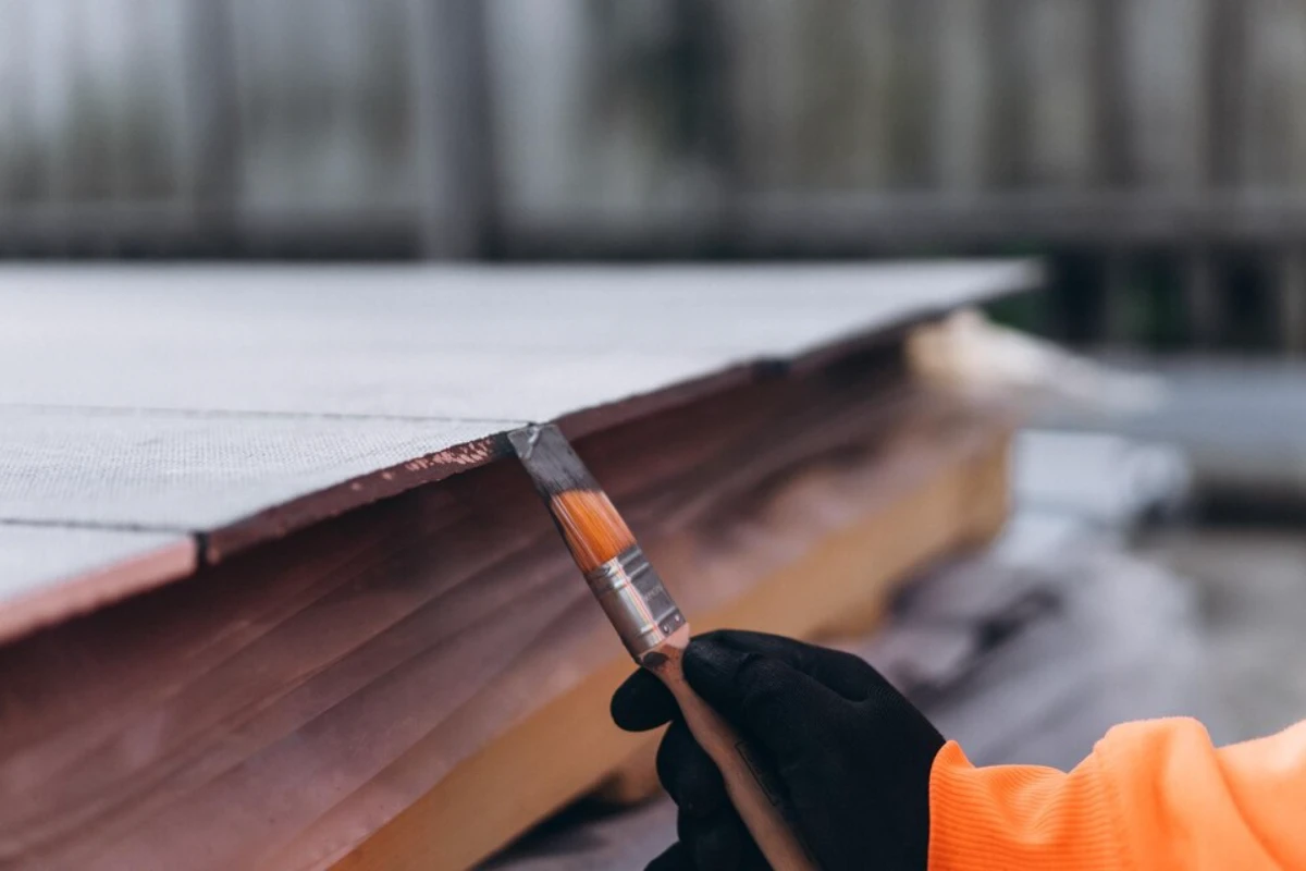 person is painting pencil with orange top