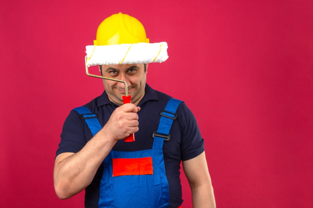 man wearing uniform standing with paint roller for DIY roof coating