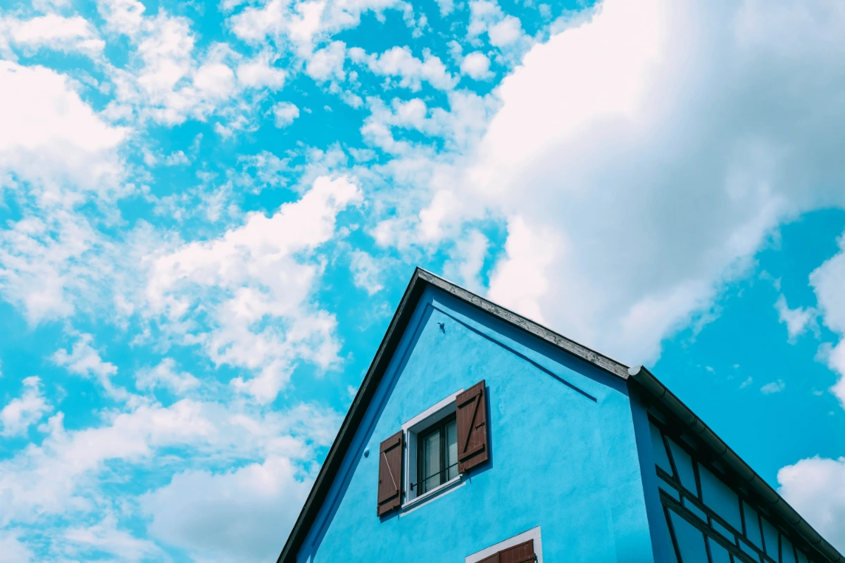 low angle shot blue farm building touching cloudy sky