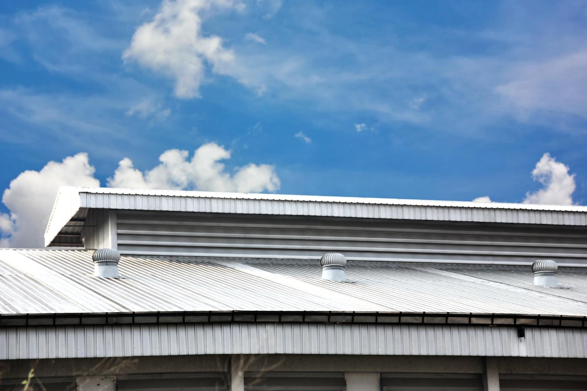 metal sheet roof tile warehouse with ventilation fan roof blue sky white cloud