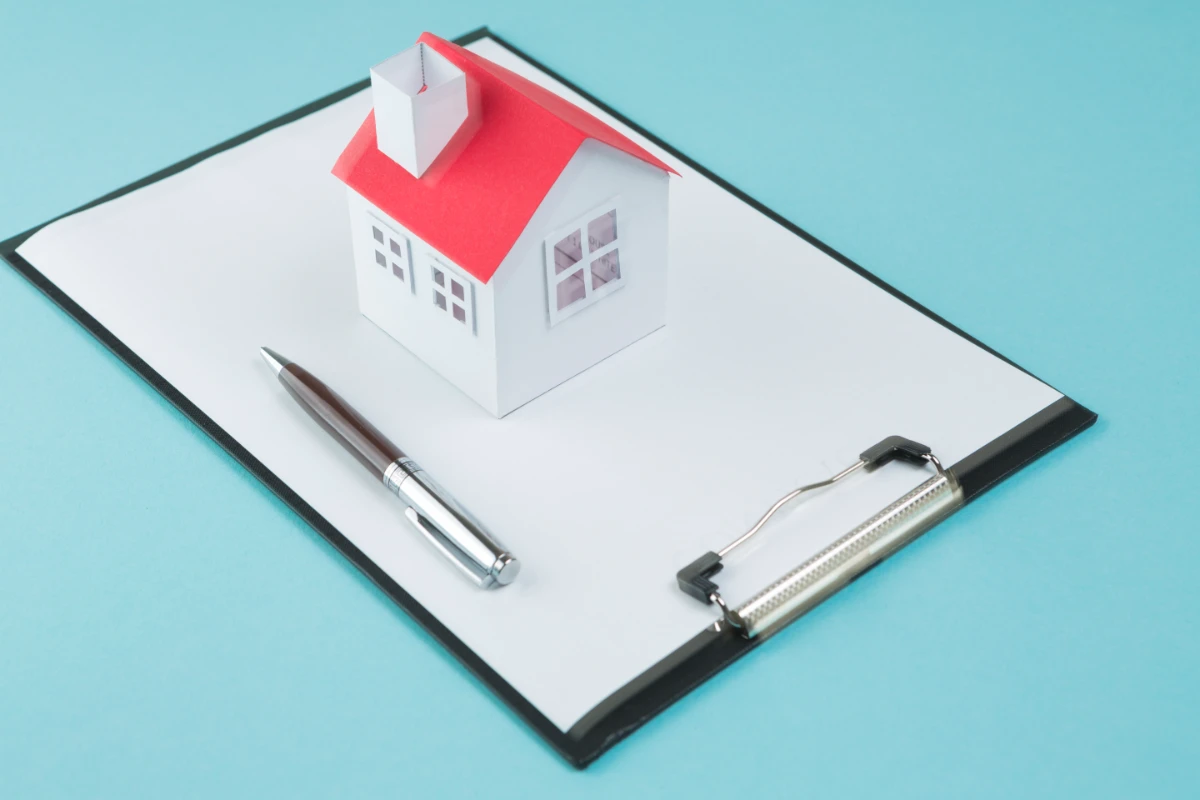 small house model pen blank clipboard blue backdrop